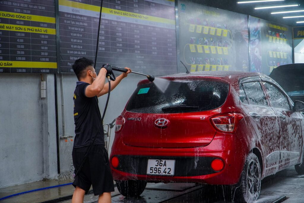 Một nhân viên của Trung tâm đang rửa xe cho khách hàng